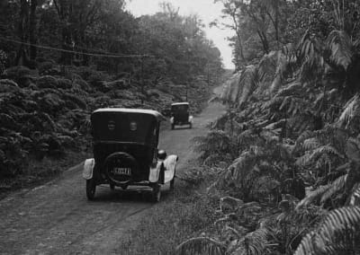 Archival photo of old car driving through Volcano on dirt road.