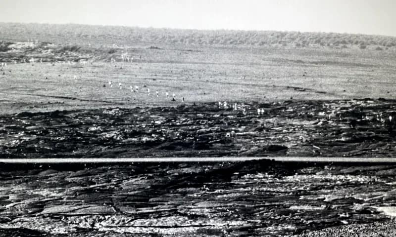 Crater Archival photo of a line of people hiking across a volcanic crater.